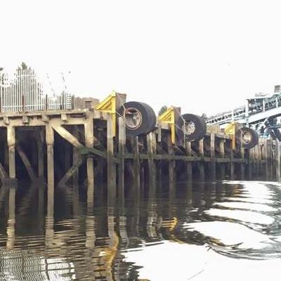 Quayside fenders and industrial structures viewed from the water